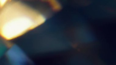 Parlak yansıma. Bulanık işaret fişeği sızıntısı. Soyut koyu siyah arkaplan üzerinde odaksız sarı mavi titreşimli renkli gökkuşağı deseni.