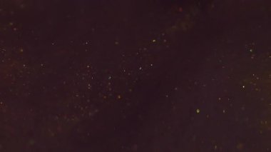 Parıltı akışı. Sanat bulanıklığı parıltısı. Parıldayan karışım parçacıkları bokeh kıvılcımlarında harmanlıyor. Renkli altın metalik boya akışı soyut arkaplan.