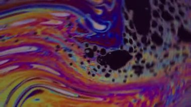 Boya girdabı. Renk karışımı. Odaklanmamış sarı mavi mürekkep yağı. Yeşil yuvarlak lekeler soyut sanat arka planına dökülüyor..