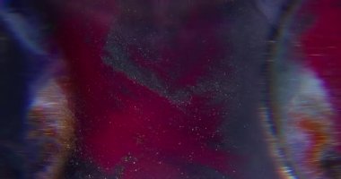 Akan boya. Bulanık parlak doku. Odaklanamayan kırmızı, mavi renkli su simleri soyut koyu siyah arkaplanda yüzüyor..