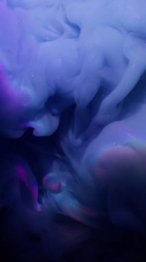 Dikey video. Mistik duman. Işıldayan sıvı. Lens ışığı arka planında mavi menekşe boya dumanı sanatsal harmanlama tonu. Odaklanamayan soyut ışıltı dokusu.