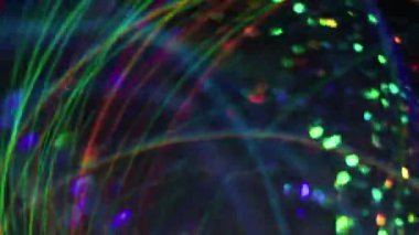 Disko parıltısı. Odaklanamayan şenlik titreşimleri. Bulanık bokeh ışık arkaplanı üzerinde hareket eden ışıl ışıl parlayan çok renkli parçacıklar..