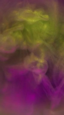 Dikey video. Boya patlamış. Duman spektrumu. Bulanık mercekte dönen altın sarısı mor simli partiküller. Soyut renk cilası sıvı karışım arkaplanı .