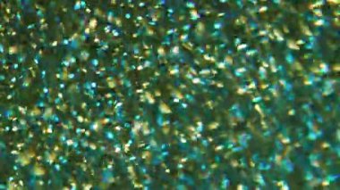Parlak ışık. Odaklanamayan kıvılcımlar. Çok renkli, sarı, mor, ışıldayan parçacıklar bulanık bokeh modern arkaplanda hareket ediyorlar..