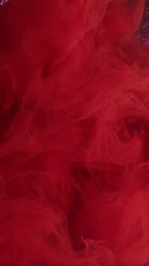 Dikey video. Hava rengi boyası. Sis dokusu. Soyut mor parıldayan sanat arka planında odaklanmış kırmızı sis, mürekkep buharı, pırıl pırıl parlıyor..