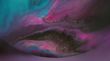 Odaklanmamış mürekkep damlası. Akrilik dökülmesi. Soyut sıvıyı karıştıran mor mavi boya. Işıldayan pigment menekşe arkaplanda çözülüyor.