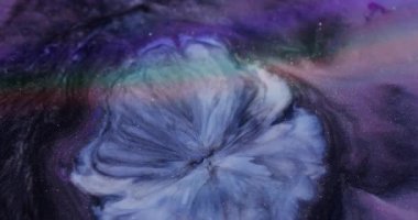 Sıçrama sanatı. Mürekkep dalgası. Bulanık mavi mor sarı renk soyut yaratıcı siyah arka planda yüzen parlak sıvı..