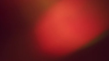 Odaklanmamış sızıntı. Lens yansıması. Kırmızı turuncu film koyu arkaplanda parlaklığı yakar. Soyut gecede ışık rengi kaybolur.
