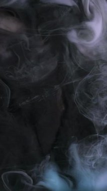 Dikey video. Bulut dumanı. Akış buharı. Odaklanmamış mavi çok renkli bulanık boya mürekkep deseni soyut sanat arka planında köpüren sıvı..