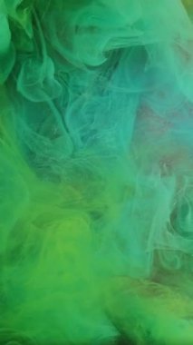 Dikey video. Yüzen sis. Akrilik boya. Odaklanmamış yeşil renk sisi desenli bulut buharı soyut parıldayan sanat arka planında ışıldıyor.