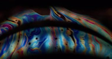 Bulanık parlama. Renkli yağ. Mavi turuncu mor mürekkep yakıt emülsiyonu siyah suda karışıyor. Gradyan çift kemerli soyut arkaplan.