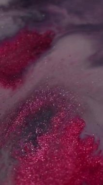 Dikey video. Akrilik karışımı. Parıltı spreyi. Bulanık pembe gri parıldayan parçacıklar boya fırıl fırıl dönen mürekkep emülsiyonu fantezi sanat soyut arka planı..