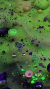 Dikey video. Kabarcık emülsiyonu. Köpük boyası. Yüzen çok renkli sanat sıvısı su dokusunu düşürür. Fantezi yeşil menekşe katmanlı soyut arka plan sıvısı.