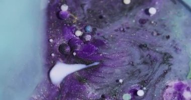 Mürekkep karışımı. Petrol emülsiyonu dökülüyor. Odaklanmamış mor mavi renkli köpük köpükleri soyut arkaplanda parlıyor..