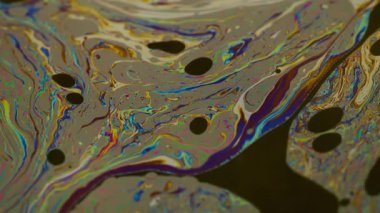 Pigment emülsiyonu. Mürekkep karışımı. Odaklanamayan mavi yeşil renk mor pembe yağ sıçraması soyut koyu siyah sanat arka planında yüzüyor..