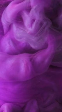 Dikey video. Fantezi dumanı. Mor duman. Yumuşak suluboya dalgalı girdaplar suda yüzer. Süzülen bulanık dokuya sahip gizemli soyut arkaplan.