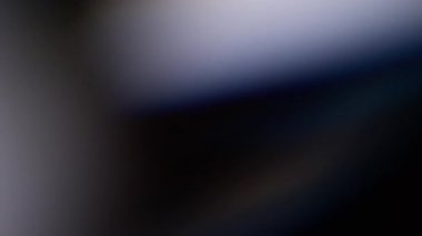 Lazer etkisi. Bulanık yansıma. Odaklanmamış mavi renkli lens parıltısı soyut koyu siyah arkaplanda kıvılcım saçar..