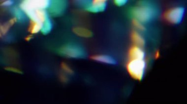 Işıl ışıl. Bulanık mercek gökkuşağı. Odaklanmamış yeşil mavi ışık parıltısı soyut sanat koyu siyah arkaplan üzerinde parıldıyor.