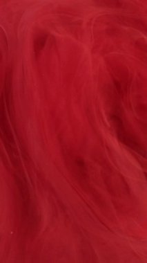 Dikey video. Mermer bulut. Duman sıvısı. Kırmızı boya, parlak toz bulutu ve gizemli su sarmalı. Odaklanmamış su soyut arkaplanındaki dalgalı suluboya.