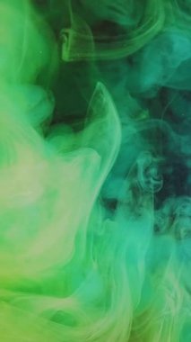 Dikey video. Duman bulutu. Boya damlası suyu. Neon yeşil renk buharı mor sim parçacıkları dokusunda süzülen hareket soyut sanat arkaplanı.