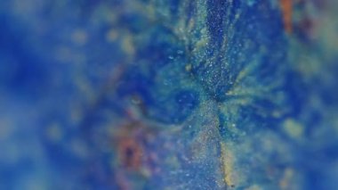 Parlayan ışık. Çözülmüş mermer dokusu. Mavi sarı renkli kumlu parçacıklar. Bokeh efektli bulanık modern arkaplanı aydınlatan boya mercekleri..