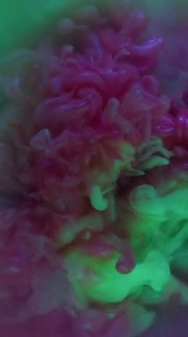 Dikey video. Duman karışımı. Mürekkep patlaması. Duman bulutu akışı sanat duellosu mor yeşil sıçrama. Işıldayan akış karışım renk su bulanıklığı patlaması soyut arkaplan daire kirişi.