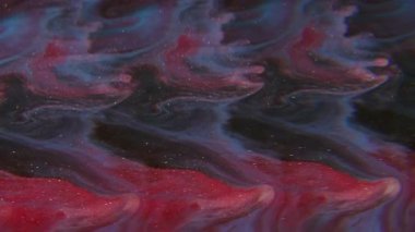 Parıltılı bir karışım. Bulanık mürekkep akışı. Renkli sim dalga mercekleri dökülüyor. Kırmızı mavi şelale boyası sıvı soyut arkaplanda çözünüyor.