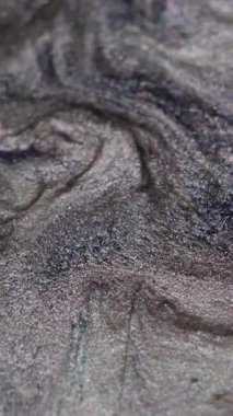 Dikey video. Işıldayan yayılma. Lüks boya. Kıymetli sıvı toz gümüş gri sanat yüzey parçacıkları dökülür. Soyut birleştirme akışları kara delik bulanık arkaplan.