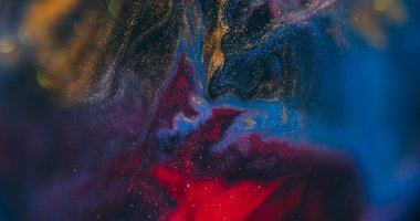 Boya dök. Bulanık parıltı dokusu. Soyut koyu siyah bokeh sanat arka planında çözünmüş mavi kırmızı renkli parlak su.