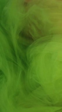 Dikey video. Çok renkli bir sis. Mermer bulut. Suda sallanan yeşil boyalı zarif kıvırcık duvaklar. Rahatlatıcı hipnotik atmosfer soyut arkaplan girdabı.