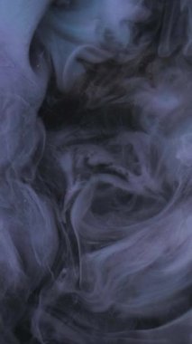 Dikey video. Mürekkep rengi. Parlak renk. Odaklanmamış koyu mor duman, parlak sis, boya bulutu, sis dokusu, soyut sanat arka planında yüzüyor..