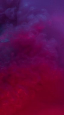 Dikey video. Mistik boya. Parıltı yayılıyor. Pembe mor parlak dalga renkli suda yuvarlanıyor. Parlak sıvı mercek mercekleri soyut arkaplan .