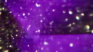 Parlak üçgenler. Odaklanamayan mercek patlaması. Bulanık bokeh ışık soyut arkaplan üzerinde hareket eden yeşil, mor, çok renkli geometrik titreşimler.