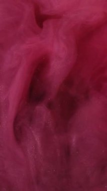 Dikey video. Duman peçesi. Parıltı akıyor. Kırmızı parıldayan yoğun sis kaotik bir şekilde salınır. Odaklanamayan mermer boya, köpüklü su özeti arka planda döner..