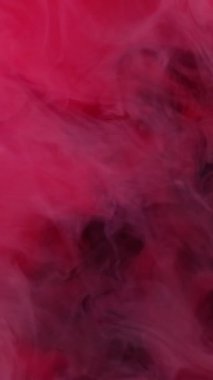 Dikey video. Duman sıvısı. Buhar dokusu. Kırmızı pembe gri renkli kaprisli sıvı sanatsal bulanık siyah arka plan. Duman pigmenti boyası. Karışık boya..