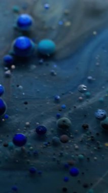 Dikey video. Sanat sıvısı. Akrilik baloncuk. Gizemli galaksi mavi gri akım jel renkli parçacıklar çözünmüş su grunge soyut arka plan üzerinde.