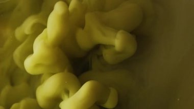 Sis dalgası. Duman bulutu. Odaklanmamış sarı renk buhar dokusu mürekkep sıvısı damlası soyut sanat arka planına yayılıyor..