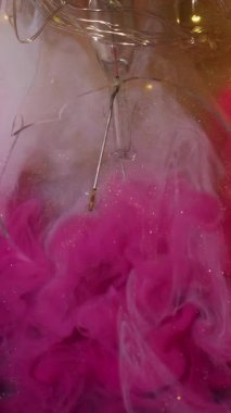 Dikey video. Parlak duman. Renkli puf. Patlayan pembe bulut boyası beyaz altın parıltılı sanat eseri, sıvı peçe arka plan sıvıları kırık cam çelenk ışıkları..