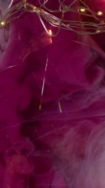 Dikey video. Sıvı karışımı. Kabarık renk. Soyut beyaz arka planda parlak pembe boya akıntıları kırık ampul. Süt gibi köpüklü suda canlı mor bulut.