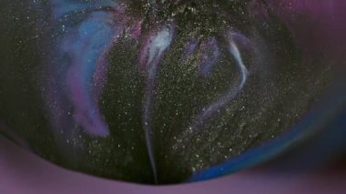 Bulanık parıltı damlıyor. Prizma sıvısı. Küre merceğinin soyut arka planında siyah parıldayan sıvı sızıntısı var. Mor mavi boya dökülmüş renk karışımı.