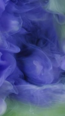 Dikey video. Hipnoz sıvısı. Sis dalgası. Mor yeşil sıvı boya dumanı girdap patlaması. Duvak boyası renk karışımı fırtına bulanık arkaplan.