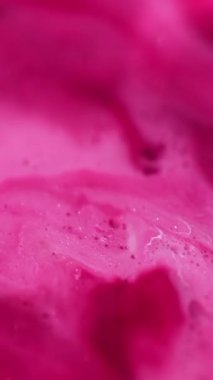 Dikey video. Bokeh sanatı. Mermer soyutlaması. Bulanık pembe, beyaz, renkli, parlak, yağ damlası, diş minesi desenli boya akrilik arka planda yüzüyor..