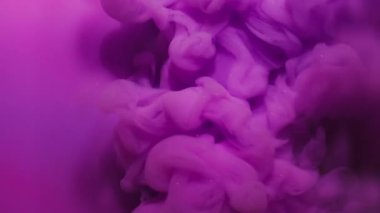 Boya sıçraması. Mürekkep sıvısı. Odaklanmamış pembe mor renkli duman dalgası soyut parlak leylak neon arkaplan üzerine yayılan girdap dokusu.
