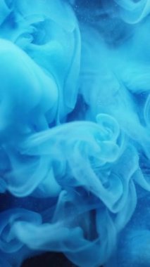 Dikey video. Duman sıvısı. Mürekkep sisi. Mavi renk akışı fantezi pigmenti bulanık parçacıklar su siyah sanat soyut arkaplan.