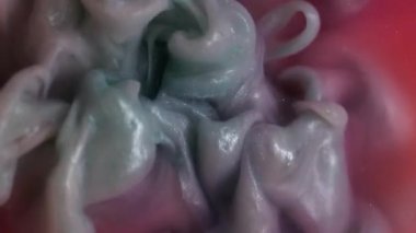 Dönen boya. Mürekkep suyu. Odaklanmamış pembe renk duman kimyasal madde sıvı dalga sıvısı soyut sanat arka planında hareket ediyor.