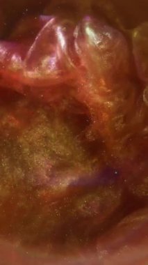 Dikey video. Duman patlaması. Parlayan mürekkep. Kahverengi turuncu dalganın sisi suda akıyor. Odaklanmamış parlak renk soyut arkaplanı.