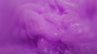 Boya buharı. Sıçrama sanatı. Odaklanmamış mor leylak rengi mürekkep parlak desen simli sıvı soyut yaratıcı bokeh arkaplanda yüzüyor..