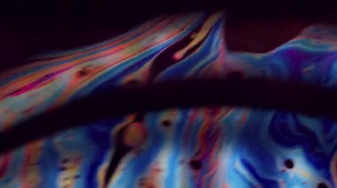 Odaklanamayan sıvı ışık. Renkli yağ. Mavi turuncu mor mürekkep yakıt emülsiyonu siyah suda karışıyor. Gradyan kemer soyut arkaplan.