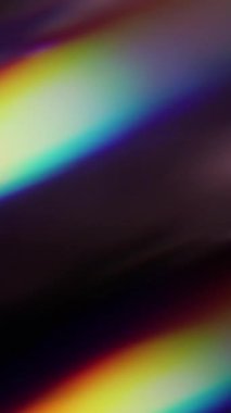 Dikey video. Bulanık ışık. Gökkuşağı arka planı. Odaklanmamış mavi yeşil renkli ışık spektrumu soyut optik sanat üzerinde parıldıyor..