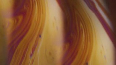 Dikey video. Emülsiyon sızıntısı. Akrilik mürekkep. Soyut koyu siyah arkaplan üzerinde yüzen sarı mor mavi renk akışı.